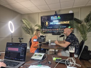 Two people are recording a podcast in a studio setup with a ring light, microphones, and a laptop; a monitor displays the 'Pixbet media lounge' logo.