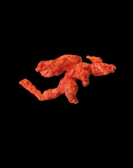 An orange, textured object resembling the Running Man internet meme sculpture isolated on a black background.