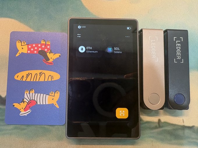The image displays a Keystone cold wallet alongside two Ledger devices, showcasing the variety of hardware wallets used for cryptocurrency security, as mentioned in the accompanying post.