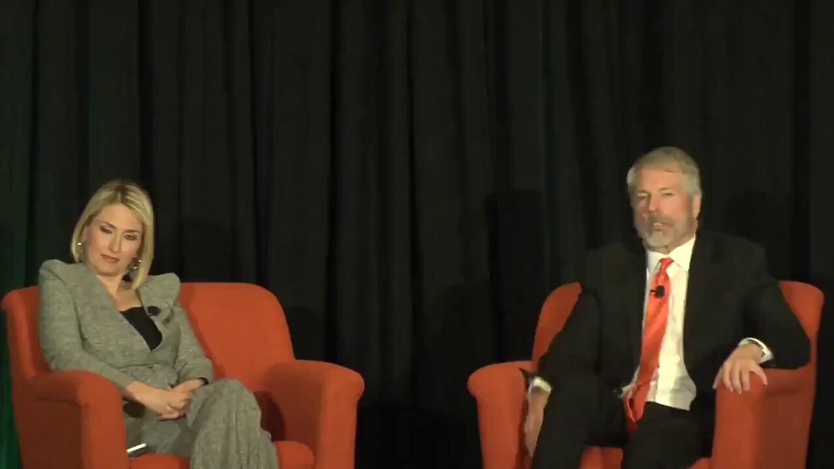The image shows two people sitting in chairs facing each other, with a microphone set up between them for an interview or discussion. The person on the left side of the image appears to be a woman wearing a gray dress, while the person on the right is a man dressed in a suit and tie. They are both seated comfortably in their respective chairs, ready to engage in conversation.

The post that includes this image features an interview with Michael Saylor, who was asked by a member of the audience about Bitcoin's impact if it were to disappear tomorrow. The question posed is "What if Bitcoin reminded me of tulips?". This implies that the person asking the question might be referring to Bitcoin as having a similar value or popularity to tulips in history.

The post also includes an image of Michael Saylor, which further emphasizes his role and expertise in the discussion about Bitcoin's impact on society.
