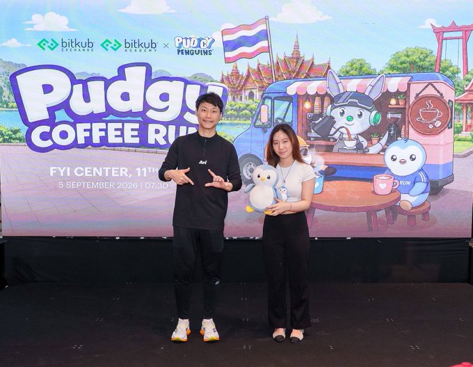 Two people posing in front of a promotional backdrop for 'Pudgy Coffee Run,' an event by bitkub academy and Pudgy Penguins at FYI Center, 11th, on 5 September 2026 at 10:30.