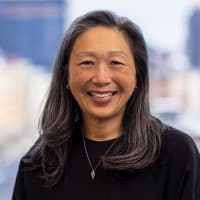 A woman with long, graying hair smiles warmly at the camera, likely Cynthia Lo Bessette of Fidelity, as she discusses how 24/7 prediction markets help set fair prices for traditional markets when they reopen.