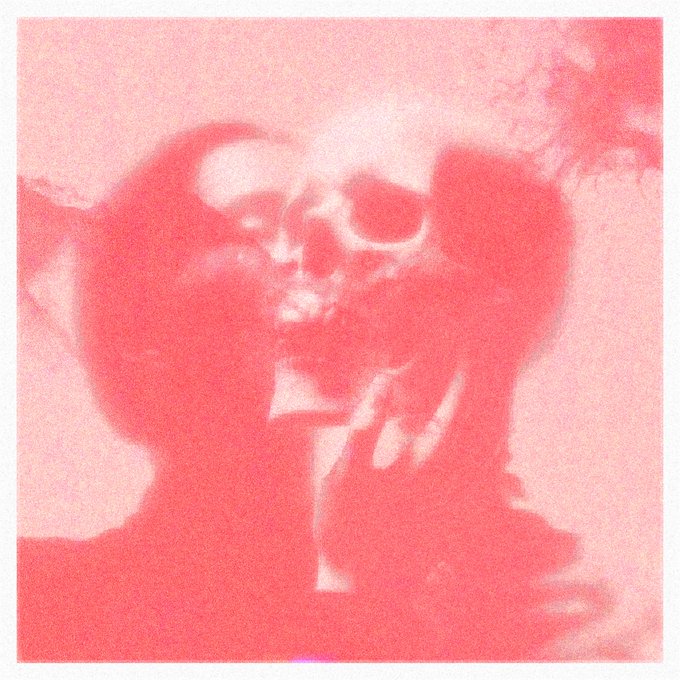 A faded, grainy photograph with a heavy pink/red color cast shows two people hugging, one wearing sunglasses.