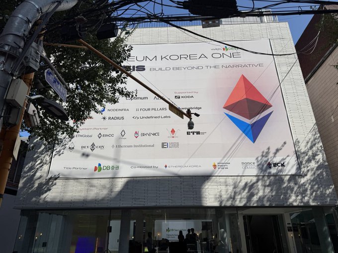 Outdoor billboard for 'EUM KOREA ONE' with the slogan 'BUILD BEYOND THE NARRATIVE', displaying the Ethereum logo and various partner logos including Pudgy, Optimism, KODA, Noon, and Radius.
