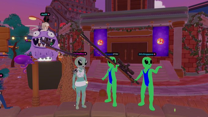 A 3D multiplayer game scene with green and gray alien characters wielding a large weapon in front of a building entrance labeled "DCLSingapore," with a purple monster creature on the left.