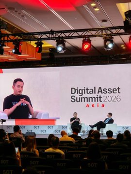 The image shows a panel discussion at the Digital Asset Summit 2026, with a speaker on stage and the "Digital Asset Summit 2026" branding displayed on the large screen behind him. The accompanying post suggests the user is attending TOKEN2049 Singapore Day 2 at Marina Bay Sands, indicating this photo captures a side event or related summit happening alongside the main conference.