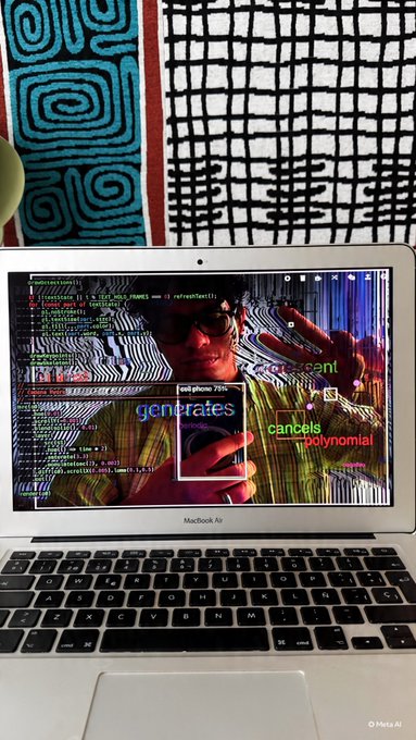 A MacBook Air laptop displays code and a video editing interface with text overlays 'generates', 'crescent', 'cancels', and 'polynomial', with a person holding a phone in front of the screen.