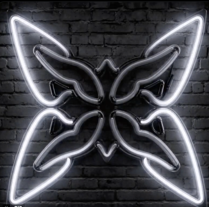 A neon light sculpture shaped like a butterfly or bat wings glows white against a dark brick wall.