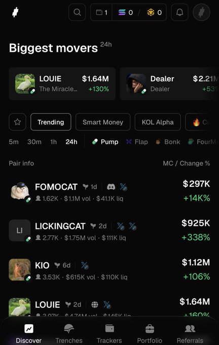 A mobile screenshot of the Trady.xyz trading terminal showing the "Biggest movers" dashboard with 24-hour data, featuring trending tokens like LOUIE (+130%, $1.64M), Dealer (+53%, $2.21M), FOMOCAT (+140%, $297K), LICKINGCAT (+338%, $925K), and KIO (+106%, $1.12M). The clean interface illustrates the post's point about Trady being an organized "system" rather than cluttered copy, with navigation tabs for Discover, Trenches, Trackers, Portfolio, and Referrals at the bottom.
