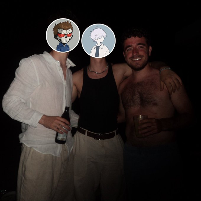 Photo of three men posing together at night with their faces partially covered by anime character stickers, one holding a beer bottle and another holding a can.