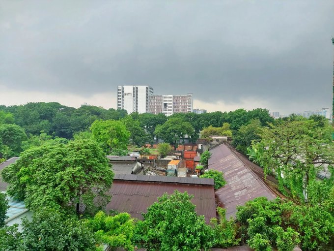The image shows a cityscape featuring buildings under an overcast sky. The perspective appears to be from above, providing a bird's eye view of the urban environment below. In the foreground, there are trees that add a touch of nature to the scene. The caption at the bottom of the image reads "Good morning everyone... Happy Friday! May your weekend be full of relaxation, good food, and great company with @NomismaNetwork and also bullish on @useTria".