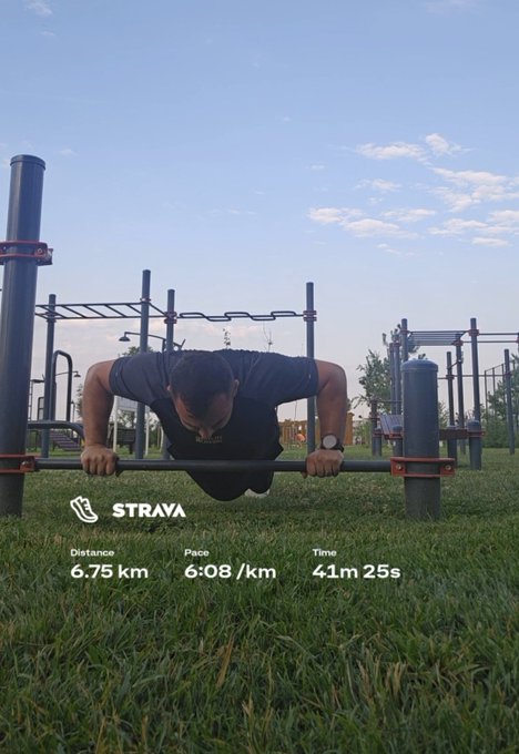 A man performs an advanced calisthenics move on parallel bars at an outdoor fitness park, captured from a low angle on the grass. A Strava overlay shows he ran 6.75 km at a 6:08/km pace in 41m 25s, tying his morning run into the #STEPN session highlighted in the post.