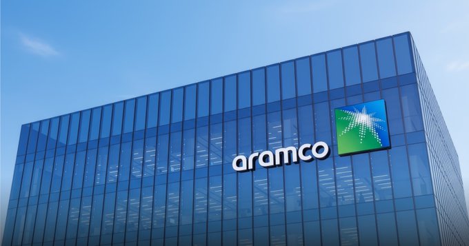 The exterior of an Aramco building with the company's logo displayed on the glass facade.