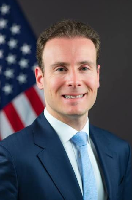 A man in a navy suit and light blue tie smiles in front of an American flag, posing for an official portrait.

The image appears to be an official government photograph that may accompany the post about the CFTC's recent guidance allowing Wall Street firms to engage with tokenized investments, lending visual authority to the regulatory news being shared.