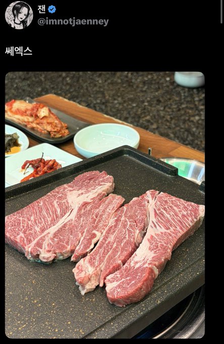 High-quality raw beef steaks are arranged on a black griddle, with side dishes like kimchi visible in the background, ready to be cooked at what appears to be a Korean BBQ restaurant. The tweet by user @imnotjaenney captures a meal outing with someone he refers to as "Jen" (shortened to 제 in Korean), matching the caption's story of dining out on an off day.