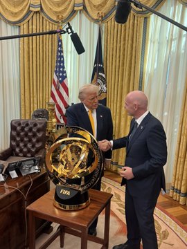 President Donald Trump and FIFA President Gianni Infantino stand in the Oval Office beside the newly unveiled "FIFA Club World Cup 26" trophy, promoting the official $FIFA World Cup commemorative coin presale.