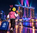 An animated character wearing an emoji mask and yellow shirt carries an ENDGAME Omega box through a neon-lit city street.