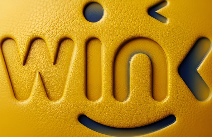 A close-up of the "wink" text with a winking face emoticon embossed on a textured yellow surface, serving as a playful visual metaphor for the post's discussion on how oracles act as the "winking eye" bridging smart contracts with real-world data.