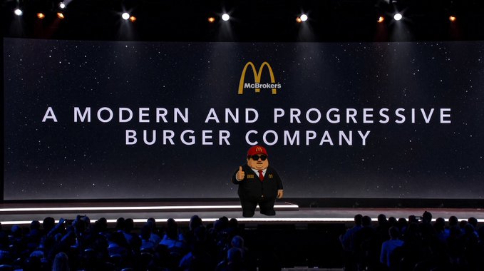 A McDonald's corporate presentation featuring the 'McBrokers' mascot on stage with a large screen displaying 'A MODERN AND PROGRESSIVE BURGER COMPANY'.