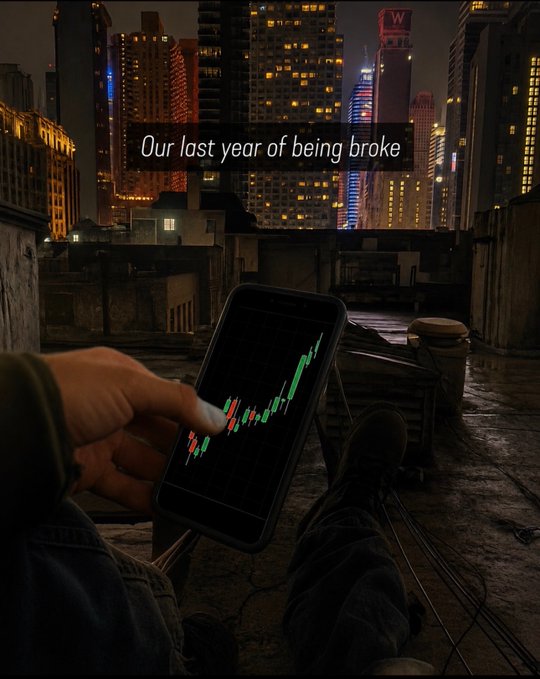 A person sits on a rooftop at night, viewing a candlestick chart with a sharp upward trend on their phone, accompanied by the text "Our last year of being broke," reflecting the post's "Manifesting" theme of aspiring financial success.
