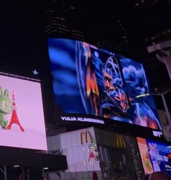 A large nighttime billboard in an urban area displays 'YUJIA KLIMOVICH' above an image of a racing driver, with a McDonald's logo and Eiffel Tower display visible nearby.