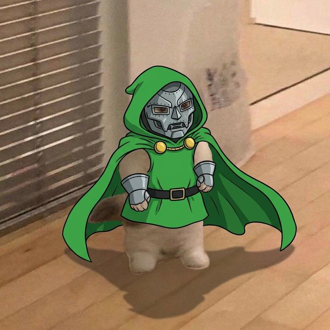 A cartoon-style image of a cat wearing a green hooded cape and a metal Doctor Doom-style mask, standing on a wooden floor.