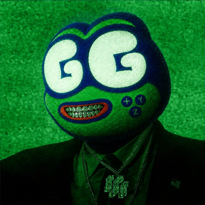 A surreal portrait features a figure in a suit wearing a mask resembling a green 'GG' character with a grill of teeth and X, Y, Z buttons on its cheek, set against a green background with a small American flag pin.