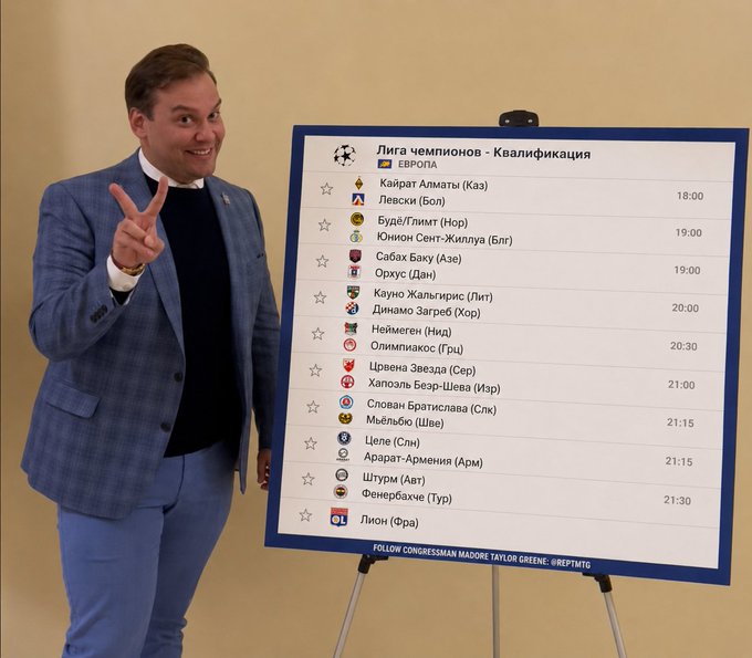 A smiling man in a blue plaid blazer points upward next to a board displaying a 'Лига чемпионов - Квалификация' (Champions League Qualification) schedule with match times and teams.