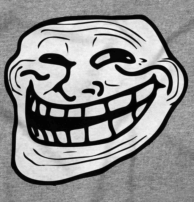 A classic "Trollface" internet meme is printed on a gray shirt, embodying the mischievous spirit of the original meme used to provoke playful reactions online. The accompanying post about the $TROLL memecoin references this iconic troll symbol as a rallying emblem for the token's community-driven comeback.