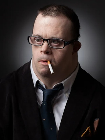 A serious-looking man in glasses, a dark suit, and tie stares directly at the camera with an unlit cigarette in his mouth, conveying skeptical disbelief. The accompanying quote mocks someone who doubts a target, and the man's deadpan, judgmental expression visually represents that "you must be crazy" reaction.