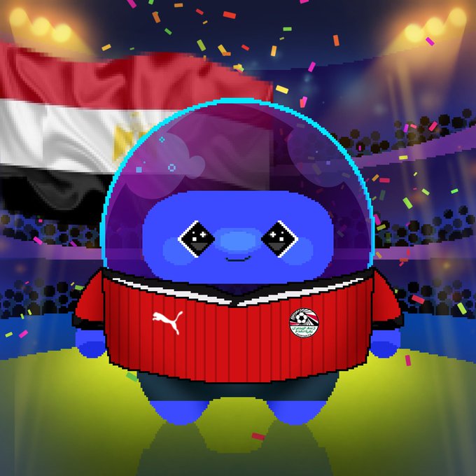 An Among Us character in an Egyptian national football jersey with Puma logo stands in a stadium with confetti and an Egyptian flag in the background.