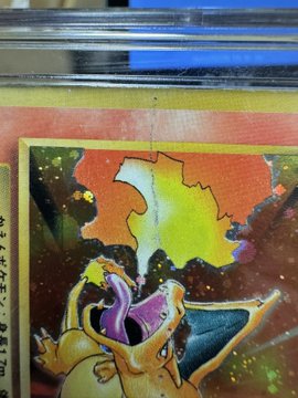 A close-up image of a Pokémon trading card displays Charizard against a fiery orange background, featuring holographic glitter effects and Japanese text.