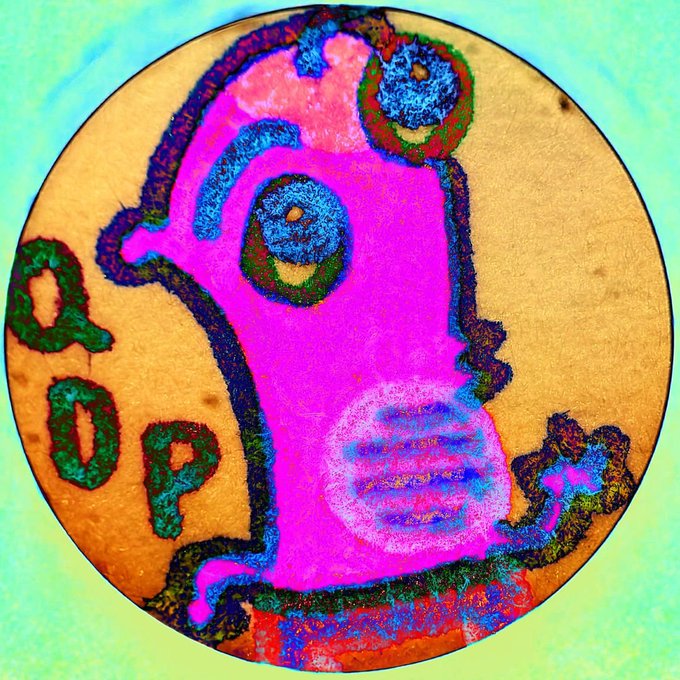 A highly saturated, psychedelic microscopic or abstract circular image shows vivid pink, magenta, green, and blue organic-looking shapes outlined in dark colors.