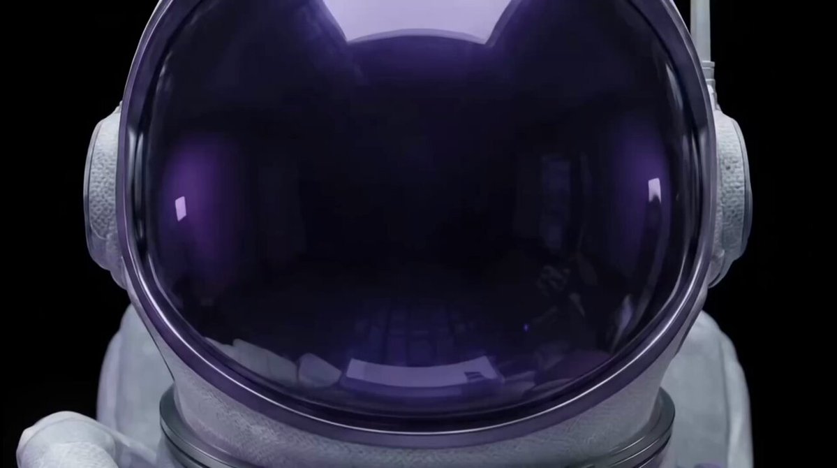 The image features a close-up of an astronaut's helmet with purple tinted glass. The helmet appears to be made of plastic or fiberglass, giving it a futuristic look. The helmet has two earpieces attached to its sides for communication purposes during space missions. The background is black and out of focus, drawing attention to the helmet as the main subject in the image.