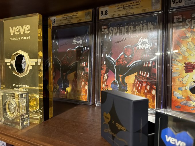 A collection of Veve digital collectibles displayed on a shelf, including CGC-graded "Superior Spider-Man Returns #1" comics with 9.8 ratings, alongside a Veve trophy presented to "Philnice272" as a top collector. The image supports the post by showcasing the impressive phygital collection that warrants Philnice272's recognition as a top Veve collector.