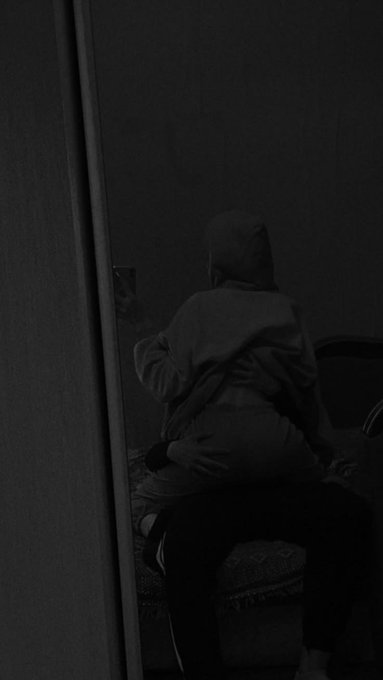 A silhouetted figure in a hoodie is seen from behind, leaning against a person seated in a dimly lit room, as the post signs off for the night while highlighting cross-chain UX work and decentralized compute infrastructure.