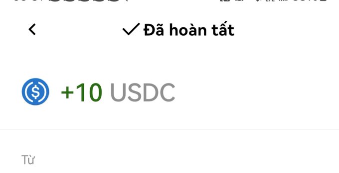 A mobile screen showing a completed transaction notification of '+10 USDC' in Vietnamese ('Đã hoàn tất').