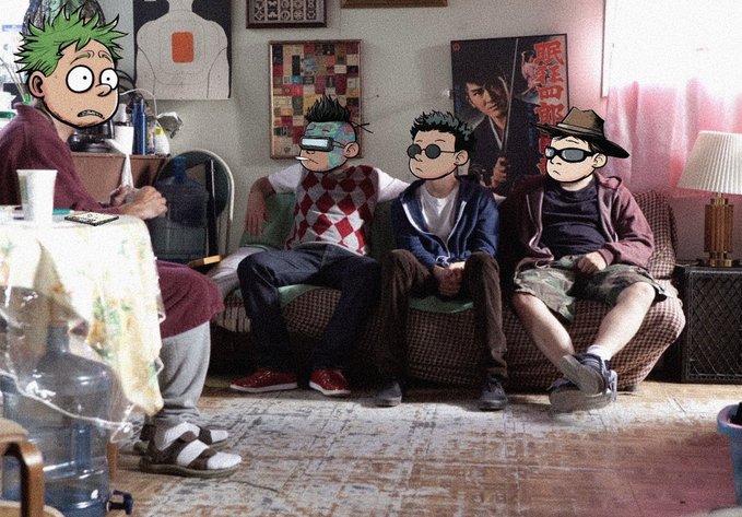 Four cartoon characters with animated eyes and hairstyles have been superimposed onto a photograph of three young men sitting on a floral couch in a cluttered living room, with a samurai movie poster visible on the wall behind them. The edit transforms the real people into animated versions, creating a humorous blend of live-action and cartoon aesthetics that matches the post's praise for the editing work.
