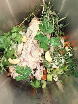 A metal mixing bowl filled with fresh herbs like rosemary, parsley, thyme, and various chopped vegetables, suggesting ingredients for a savory stock. The caption "have you taken the stock pill" humorously plays on the word "stock," linking the kitchen ingredients to financial markets.