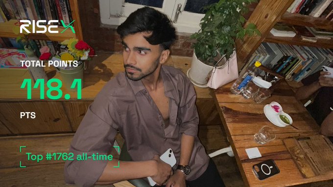 A young man sits in a room filled with books and plants, with on-screen graphics displaying "RISEX," "TOTAL POINTS 118.1 PTS," and "Top #1762 all-time," visually confirming the 118 points achievement mentioned in his caption about his trading results.