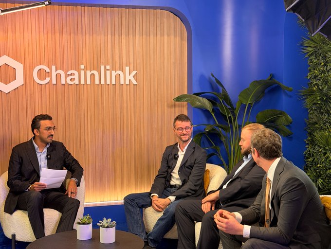 Four men in business attire sit in a panel discussion setting with a "Chainlink" branded backdrop, engaging in a conversation about agentic AI in custody and asset servicing at the Sibos event, featuring Chainlink co-founder Sergey Nazarov alongside representatives from J.P. Morgan and GLEIF.