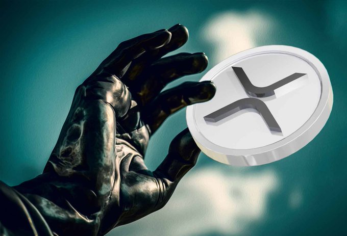 A dark, sculpted hand reaches toward a large silver coin bearing the XRP cryptocurrency logo against a teal background, visually symbolizing investors continuing to "hold" their XRP tokens. The imagery reinforces the post's message about lingering holders of $XRP despite current price levels.