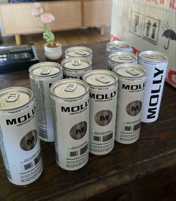 Several silver cans labeled "MOLLY - CRYPTO IN A CAN" with "WWW.GETMOLLY.COM" and a Monero-style "M" logo are arranged on a wooden table, reinforcing the post's description of a beverage that combines a drink with real crypto and NFT redemption via its on-can QR code.