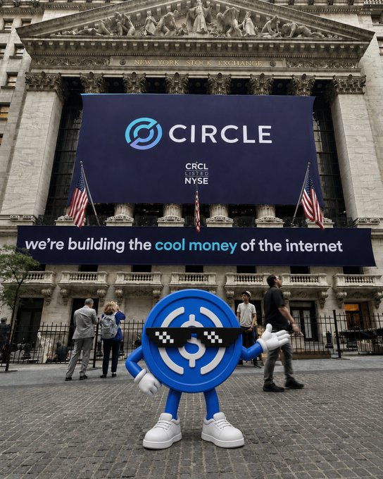 The USDC mascot stands in front of the New York Stock Exchange adorned with a banner reading "CIRCLE - CRCL LISTED NYSE - we're building the cool money of the internet," celebrating Circle's IPO listing on the NYSE under the ticker CRCL.