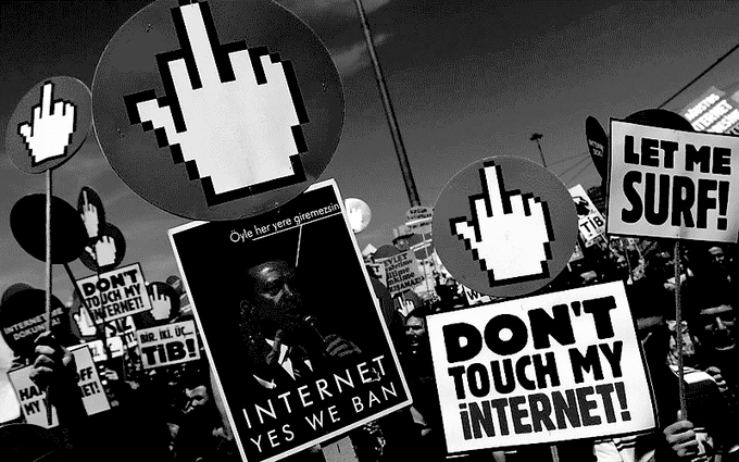 A black-and-white image of a protest featuring signs reading "DON'T TOUCH MY INTERNET!" and "LET ME SURF!" alongside large pixelated cursor symbols, with a central poster reading "INTERNET, YES WE BAN" and "Cyle her yere giremezsin!" — visually referencing $DOT (Polkadot) and its role in championing decentralized, censorship-resistant internet freedom.