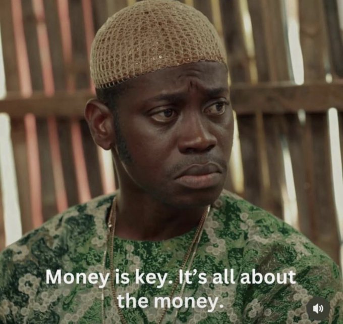 A man wearing a crocheted cap and green patterned shirt, with the subtitle 'Money is key. It's all about the money.'