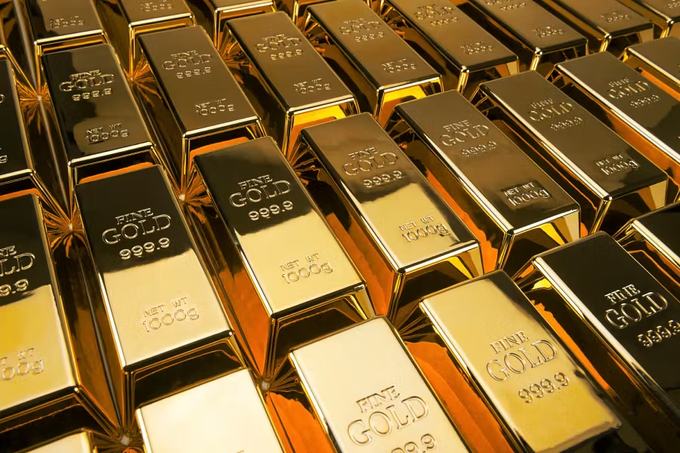 A close-up photograph of numerous stacked gold bars, each stamped with 'FINE GOLD 999.9' and 'NET WT 1000g,' representing precious metal bullion.