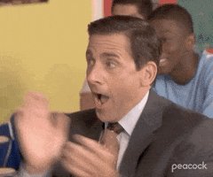 The image features a man dressed in a suit, with his hands clapping together in surprise or excitement. He appears to be wearing a tie as well. In the background, there are other people present but they are not the main focus of the image. The caption "first scratch incoming" suggests that this is an early draft of a post and might contain errors or need further editing before being published on the platform.