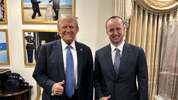 Donald Trump poses with a man in a suit, with photos of Trump and military personnel on the wall behind them, and a "Trump" hat in the foreground. This image is likely included to represent "Trump" in the context of the post's discussion of Truth Social.