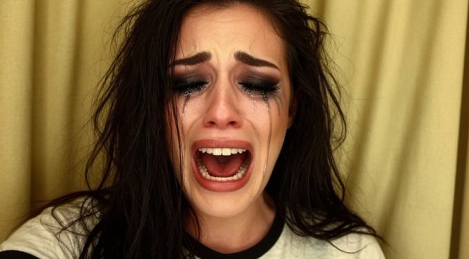 The image shows a woman with long hair wearing a white shirt, tears streaming down her face as she looks directly at the camera. The caption of the image reads "Focus on what is in the image and how it relates to the post". This suggests that the content of the image may be related to Bitcoin or cryptocurrency, which could explain why the woman appears upset or distressed.